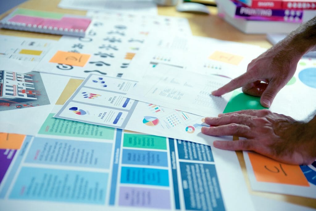 Des mains pointent du doigt un document lors d'une séance de brainstorming à l'agence bb&b, conseil en communication et marketing industriel